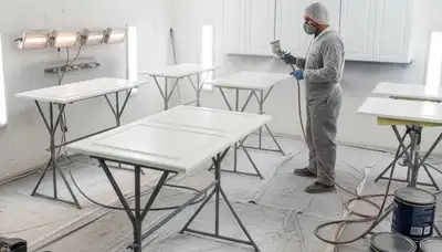 Professional cabinet painting process in Tampa, FL using spray and brush techniques for smooth kitchen finishes