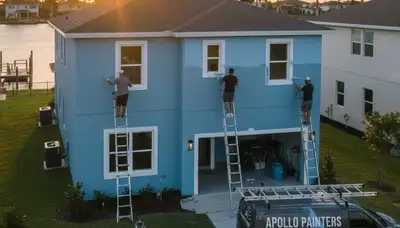 Professional house painters working on exterior home repaint project in Tampa, FL